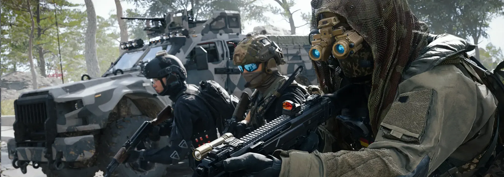Three operators moving through a forest beside an armoured vehicle